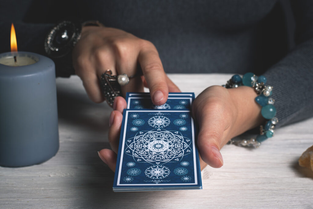 Giulia zeigt einer Kundin die Tarotkarten damit sie die Tageskarte ziehen kann.